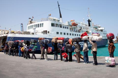 Migrants prepare to board a boat in Libya to evacuate.